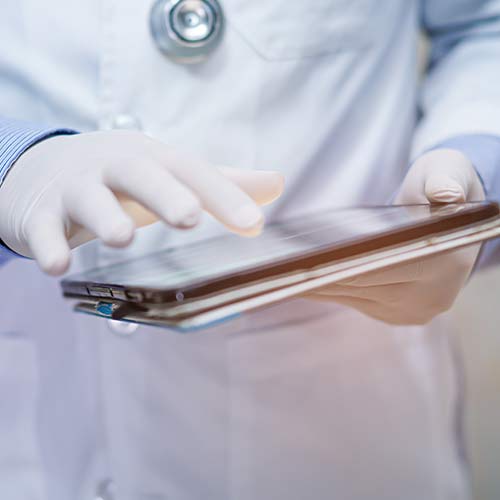 veterinarian wearing gloves performing research on ipad